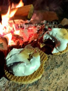 dutch s'mores in front of campfire at night