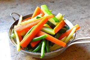 blanched vegetables in a strainer