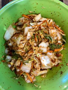 cabbage, vegetables, and seasoning mixed into large bowl