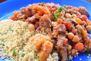 moroccan lamb stew and couscous on a blue camping plate