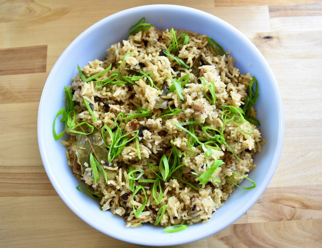 large bowl of dirty rice topped with green onions