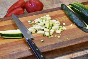 zucchini being cut on cutting board