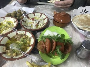 a table full of breads, dips, and vegetables