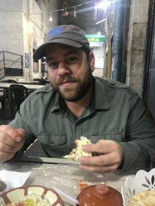 man eating bread at a table in Amman