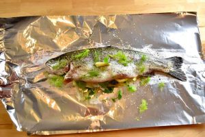 fish stuffed with vegetables on aluminum foil