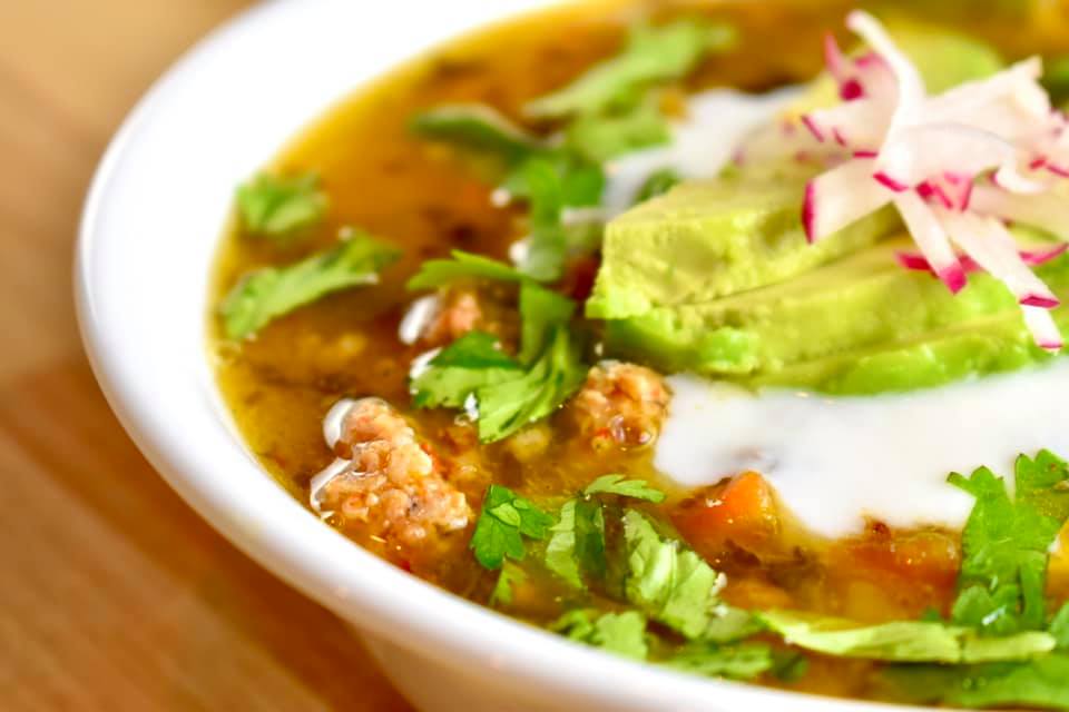 chicken, chorizo, white bean soup, topped with avocado, sour cream and radish