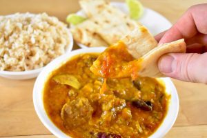 Indian bread dipping into dal