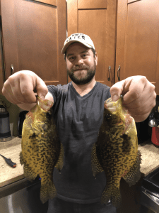 me holding two freshly caught crappie