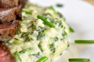 Venison steaks with creamed hominy and pigweed